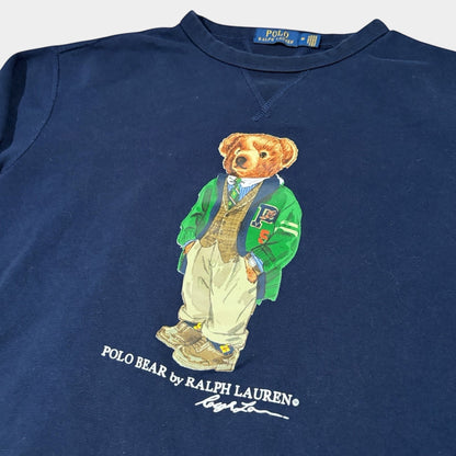 THE YRDSALE navy crewneck sweatshirt with a graphic of the Polo Bear by Ralph Lauren wearing a green varsity jacket and tan trousers.