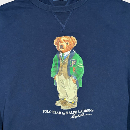 Navy crewneck sweatshirt by Ralph Lauren featuring a graphic of the Polo Bear wearing a green letterman jacket, vest, and khakis.